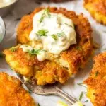 Homemade crab cake recipe with golden crust, served with lemon wedges and dipping sauce